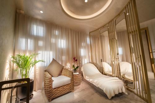 a bedroom with a mirror and a chair and a bed at The Biltmore Hotel Villas, Dubai in Dubai