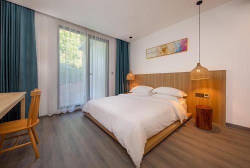 a bedroom with a large bed and a large window at Healing House--Free one way pick up service over 2 nights in Zhangjiajie