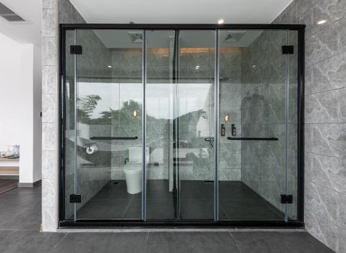 a bathroom with a glass shower with a toilet at Healing House--Free one way pick up service over 2 nights in Zhangjiajie