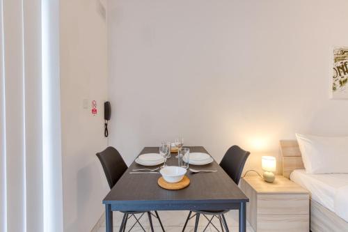 una sala da pranzo con tavolo, sedie e un letto di New Studio in Msida a Msida