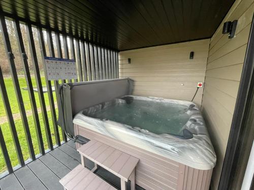 a jacuzzi tub with a bench in a building at River Logie Lodges in Westfield