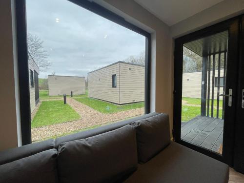 a living room with a couch and a large window at River Logie Lodges in Westfield