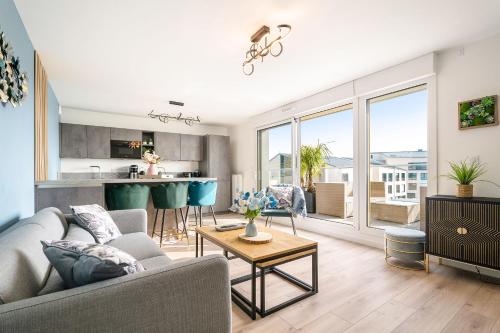 un salon avec un canapé et une table dans l'établissement Appartement saint malo neuf, 2 chambres, terrasse, garage, à Saint-Malo