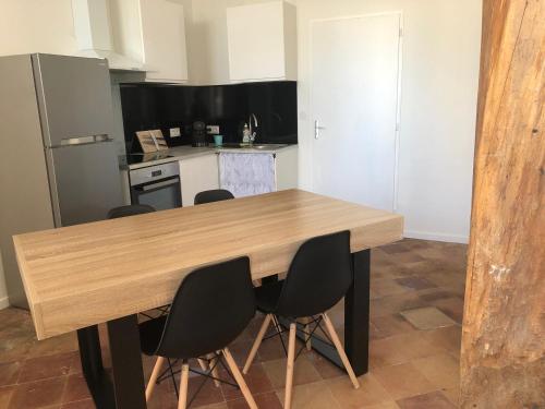 une cuisine avec une table en bois et quatre chaises dans l'établissement Le charme au fil de l eau jardin barbecue pour 4 personnes, à Castelnaudary