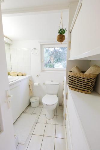 une salle de bain blanche avec des toilettes et un lavabo dans l'établissement Le Charmeur - Le Chalet Attrape-Coeur, à Aix-en-Provence