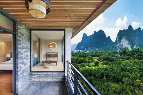 a house with a view of the mountains at Li-river Island Resort Xingping Yangshuo in Yangshuo
