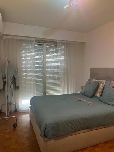 une chambre avec un lit et une fenêtre avec des rideaux dans l'établissement Appartement face a la mer, à Nice