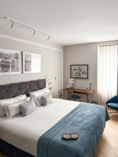 a bedroom with a large bed with a blue blanket at Lasala Plaza Hotel - Adults Only in Donostia-San Sebastián