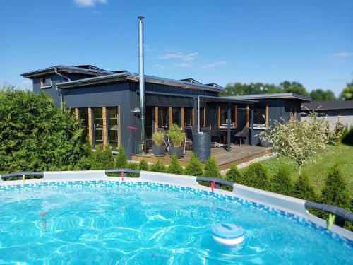 a house with a swimming pool in front of a house at Happy-Nest in Oberkrämer