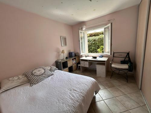 une chambre avec un lit, un bureau et une fenêtre dans l'établissement Villa mer piscine, à Carry-le-Rouet