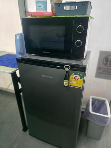 a microwave sitting on top of a refrigerator at Beautiful Studio 107 Apartment with nice living room with WiFi in Bangkok