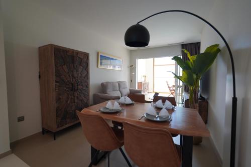 a dining room with a table and a room with a couch at Intempo by Holuxe - 024 - 2nd floor in Benidorm