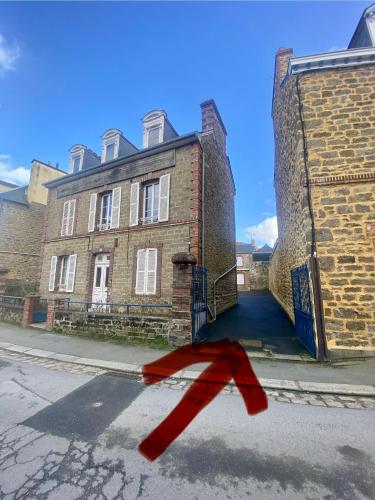 a red arrow on the street in front of a building at Le Coin Tranquille in Dinard
