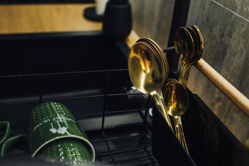 a pair of gold spoons and a green cup at ForRest Glamp Saulkrasti in Saulkrasti
