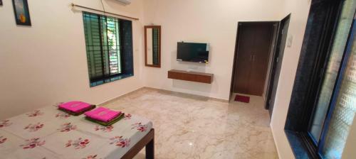 a living room with a table and a television at Rama Niwas Beach Home Stay in Pawas