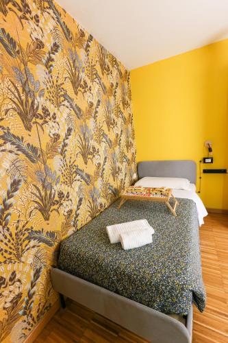 a bedroom with a bed and a yellow wall at casa dolce casa in Rome