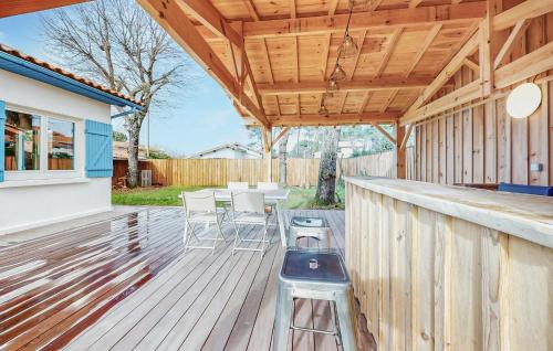 une terrasse en bois avec un bar, une table et des chaises dans l'établissement Awesome Home In La Teste-De-Buch, à La Teste-de-Buch