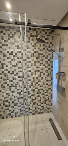 a shower with a glass door in a bathroom at Costamar Martil in Martil