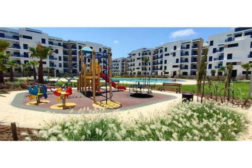 a playground in front of a large apartment complex at Costamar Martil in Martil
