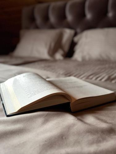 an open book sitting on top of a bed at Sodyba Amberwood house in Petroškai