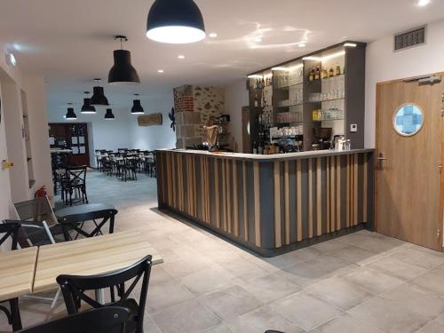 un restaurant avec un bar, des tables et des chaises dans l'établissement Chanceux pressignac Rochechouart Chabanais, à Pressignac