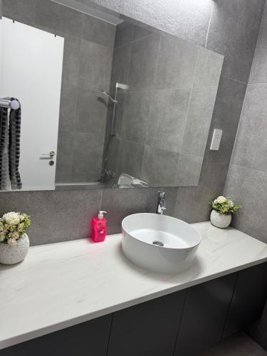 a bathroom with a white sink and a mirror at Amazing vacation villa in paphos 3 Bedrooms in Khlorakas