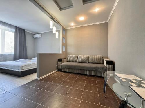 un soggiorno con un divano e un letto di ApartPoltava Світлі та стильні апартаменти в центрі Полтави біля театру Гоголя, ЦУМ, банківський ЧЕК a Poltava