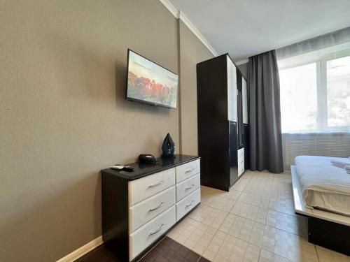 una camera da letto con un letto e una TV a parete di ApartPoltava Світлі та стильні апартаменти в центрі Полтави біля театру Гоголя, ЦУМ, банківський ЧЕК a Poltava