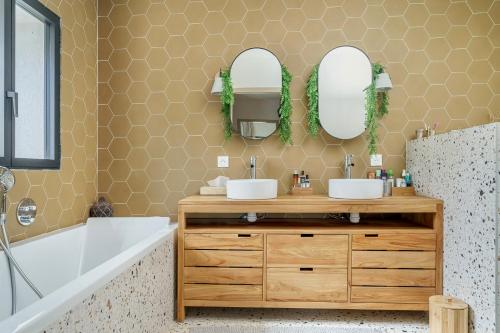 une salle de bain avec deux lavabos et deux miroirs dans l'établissement Mazargues, à Marseille