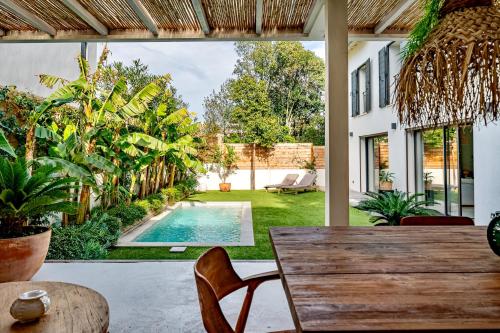 un patio extérieur avec une table et une piscine dans l'établissement Mazargues, à Marseille