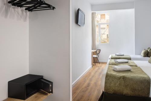 a bedroom with two beds and a tv on the wall at htop BCN City #htopEnjoy in Barcelona