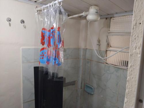 La salle de bains est pourvue d'une douche avec rideau de douche. dans l'établissement Casa no Centro de Tinguá, à Nova Iguaçu