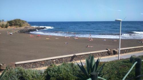 a group of people on a beach near the ocean at Gardenia apartment in La Estrella