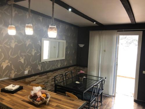 a dining room with a glass table and a dining at Gardenia apartment in La Estrella