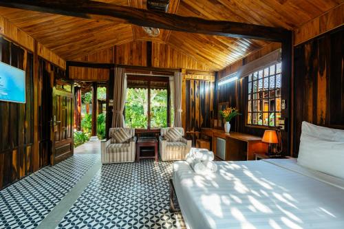 a bedroom with a bed and a table and chairs at Herbal Resort & Spa in Phu Quoc