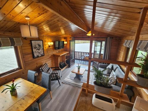 an open living room with wooden walls and ceilings at Ant River Lodge Houseboat in Stalham