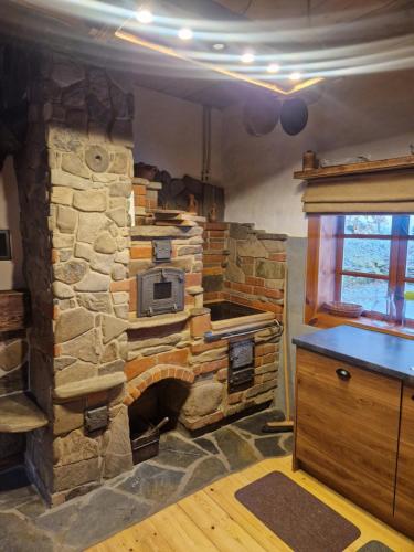 a stone oven in a kitchen with a stone wall at Dom Nad Strumykiem in Bielanka