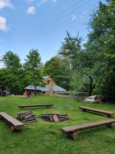a group of benches around a fire in a field at Dom Nad Strumykiem in Bielanka