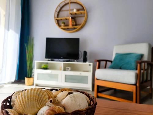 a living room with a table with a basket of shells at Miami de Portugal apartment in Portimão