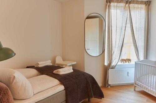 a bedroom with a bed with a mirror and a crib at Stunning 2 BR Home on Nyhavn with Private Balcony in Copenhagen