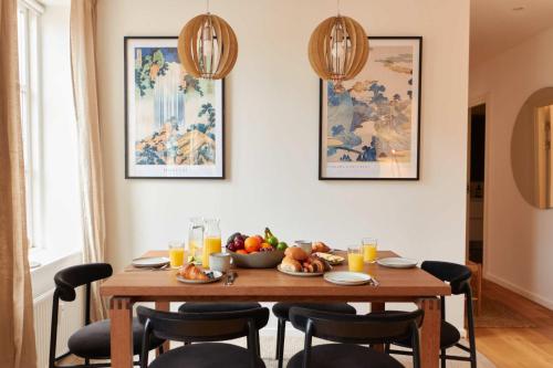 a dining room table with a bowl of fruit on it at Stunning 2 BR Home on Nyhavn with Private Balcony in Copenhagen