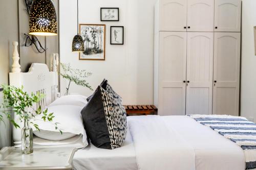 a guest bedroom with a white bed and white cabinets at Seaforth Country House in Ballito