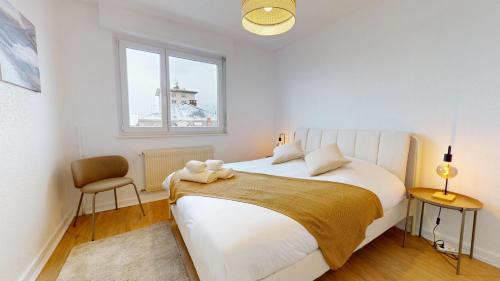 une chambre avec un grand lit blanc et une fenêtre dans l'établissement La belle étape avec parking, à Colmar