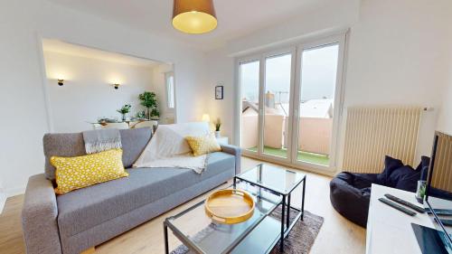 un salon avec un canapé et une table en verre dans l'établissement La belle étape avec parking, à Colmar