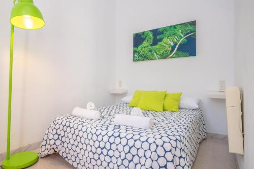 a bedroom with a bed with green and white sheets at Can Calpe in Can Picafort