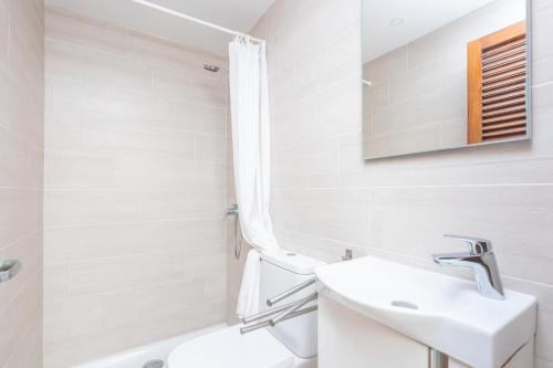 a white bathroom with a sink and a toilet at Can Calpe in Can Picafort