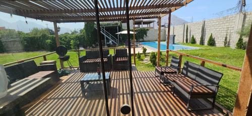 a wooden deck with benches and a swimming pool at Casa Cipres in Laredo Hacienda