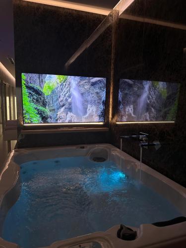 a bath tub with two monitors in a room at Hotel Queen in Tirana