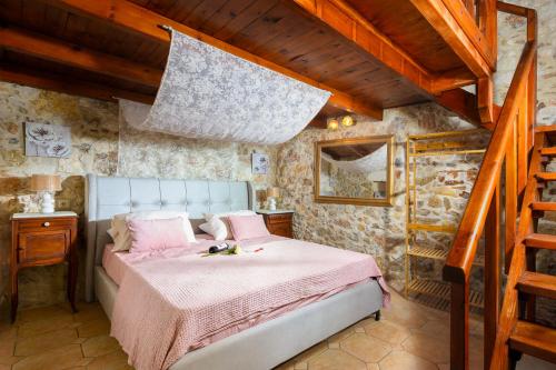 ヘルソニソスにあるManuelo Relaxing Villaのベッドルーム1室(ピンクのシーツが敷かれたベッド1台、階段付)