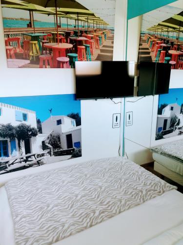 - une chambre avec un lit et une télévision dans l'établissement Royan congrés, à Royan